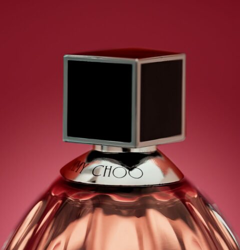 Gros plan d'un parfum Jimmy choo sur fond rose dégradé